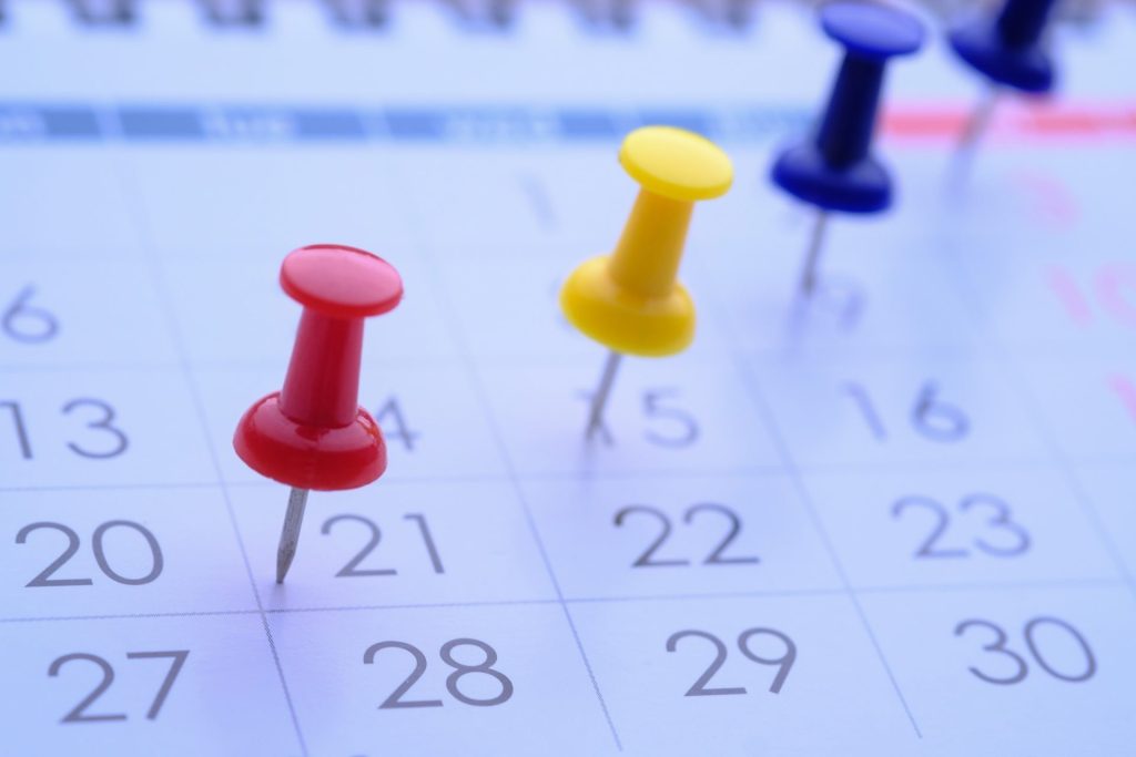 Bright and Colorful Push Pins on Calendar Dates for Enhanced Organization and Efficient Scheduling